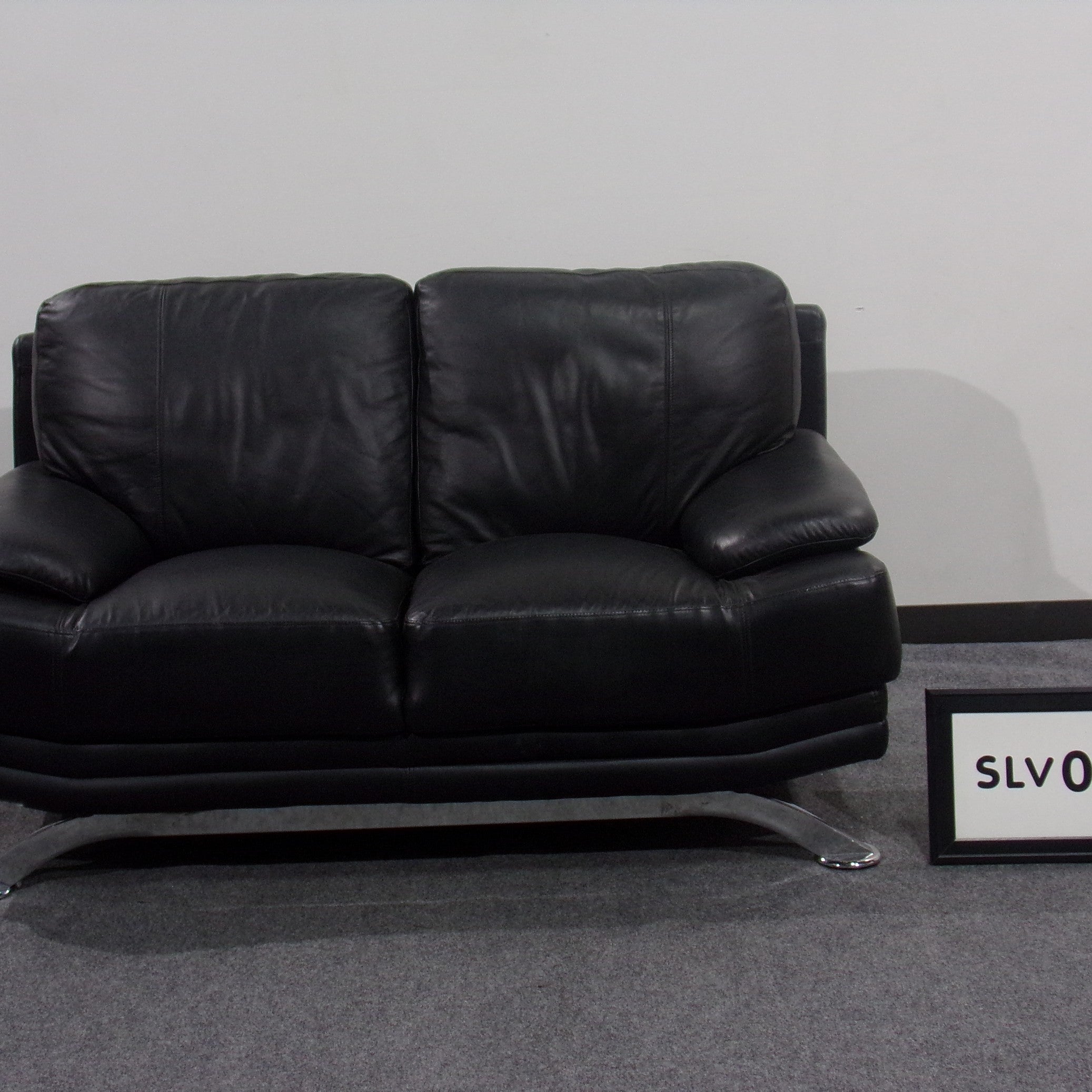 Two cushion love seat Black leather w/ chrome base legs